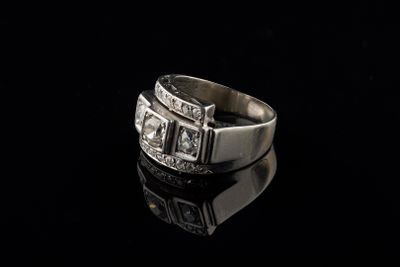 un gros plan d'une bague en argent sertie de diamants sur un fond noir