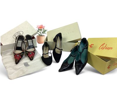 trois paires de chaussures sont posées dans une boîte à côté d'une fleur