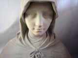 a statue of a woman with a hood on her head