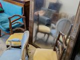 un grand miroir posé par terre à côté d'un canapé bleu