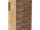 un vieux livre à la couverture brune posé sur une surface blanche