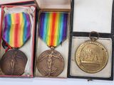three medals in a box with a ribbon and ribbon around them