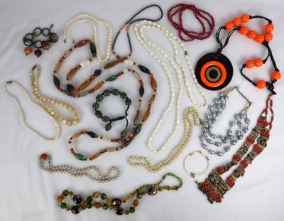 de nombreux colliers et bracelets disposés sur une surface blanche
