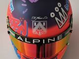 Le casque d'une personne est recouvert de graffitis sur une surface blanche.