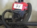a red and black vacuum with a sign on it