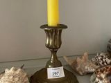 a candle that is sitting on a shelf next to some shells