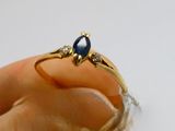 a person holding a ring with a blue stone on it