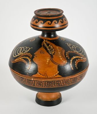 a black and orange vase with a woman on it