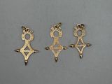 three gold earrings with a crown and a cross on them