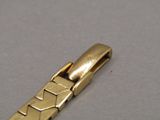 a close up of a gold bracelet on a table