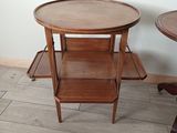 a small table with a shelf on it in the corner of a room