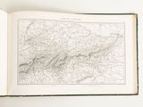 an open book on a table with a map of the mountains