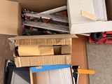 un carton rempli de boîtes et d'outils posé par terre