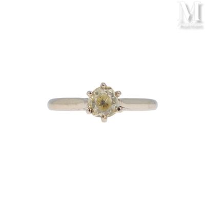 un gros plan d'une bague sertie d'un diamant jaune sur fond blanc