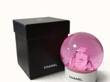 a pink snow globe sitting next to a black box
