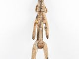 an image of a wooden sculpture of a man holding a baby