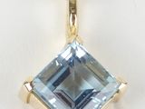 a close up of a blue topaz pendant on a white background