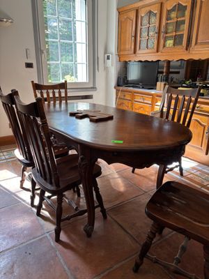 une table et des chaises en bois dans une cuisine dotée d'une fenêtre