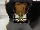 a black and gold clock with a key in it