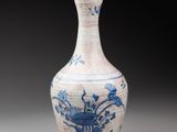 blue and white vase with flowers and birds on it on a gray surface