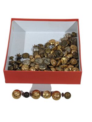 a red box filled with lots of gold and silver buttons