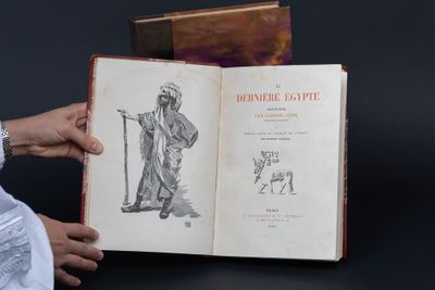 une personne tenant un livre ouvert sur lequel figure un dessin