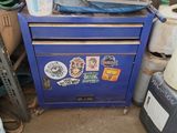 une photo d'une armoire bleue sur laquelle s'entassent toutes sortes d'objets