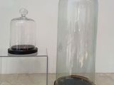 a glass clochet and a glass stand with a clock on it