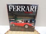 a red ferrari book sitting on top of a wooden table