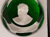 une assiette en verre vert sur laquelle est représenté le buste d'un homme