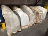 many pieces of furniture wrapped in plastic in a warehouse