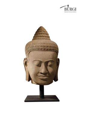 an image of a stone head of a buddha on a stand