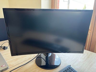 un écran d'ordinateur posé sur un bureau, avec un clavier à côté
