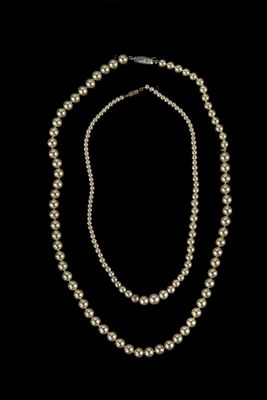 un ensemble composé d'un collier et d'un bracelet en perles blanches sur fond noir