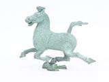 une petite statue représentant un cheval au galop sur un fond blanc