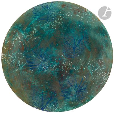 a close up of a circular metal plate with blue and green designs on it