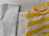 a yellow and white shirt and white pants on a table