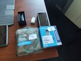 un ordinateur portable, un téléphone portable, un disque dur et un chargeur posés sur un bureau