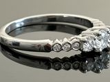 a close up of a diamond ring on a reflective surface