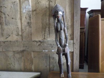 a statue of a monkey sitting on a wooden table