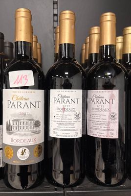 several bottles of wine are lined up on a shelf in a store