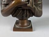 bronze statue of a woman holding a bird on a wooden base
