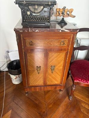 an old typewriter sitting on top of a wooden cabinet