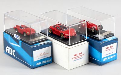 trois modèles réduits de voitures dans une vitrine posée sur un support blanc