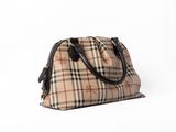 le petit sac vintage à carreaux est posé sur une surface blanche