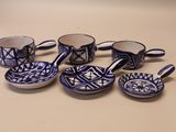 plusieurs tasses et soucoupes bleues et blanches posées sur une table