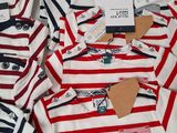 a lot of shirts that are sitting on a table