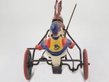 figurine of a rabbit in a toy car on a white background