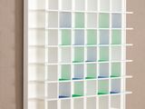 a picture of a white book shelf with green and blue squares on it