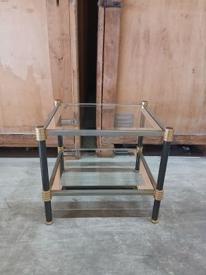 a glass and brass coffee table in the middle of a room